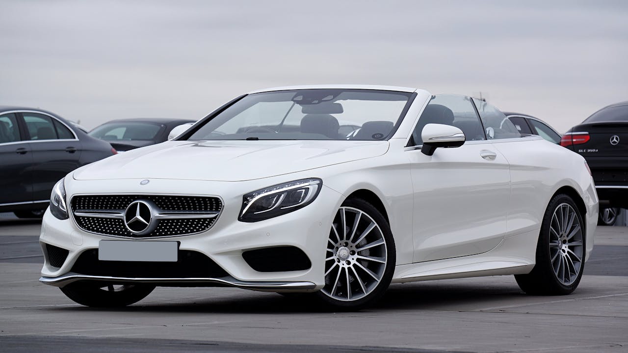 Elegant white Mercedes-Benz convertible parked outdoors, showcasing luxury and style.