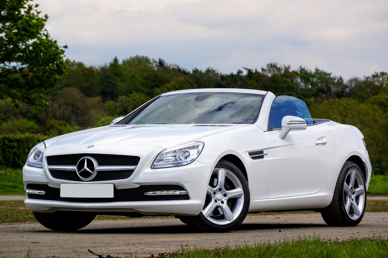 Elegant white Mercedes-Benz SLK convertible parked in a scenic outdoor setting.